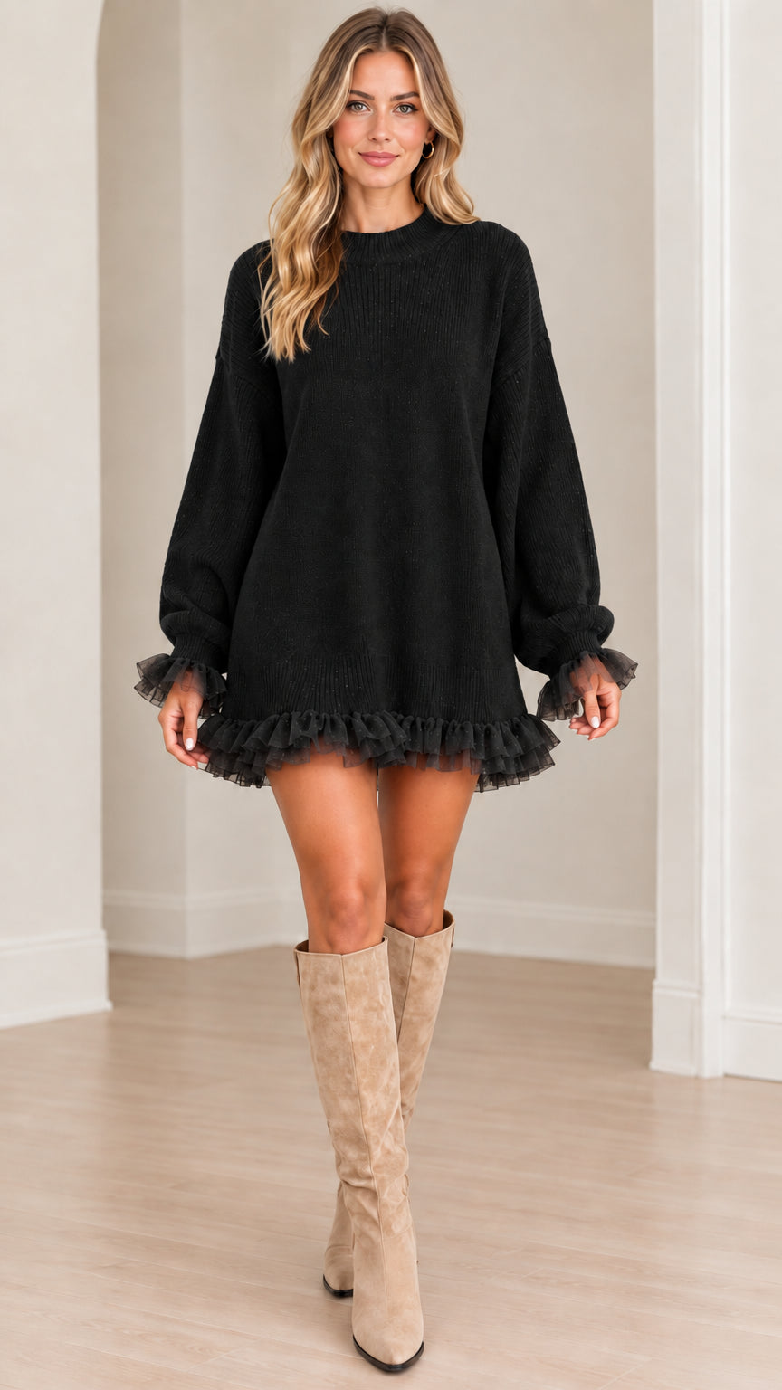 Front full-length view of model wearing black knit sweater dress with tulle ruffle trim